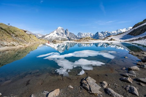Mountain landscape with mountain lake and ice floe, water reflection in Lac Blanc, mountain peak,