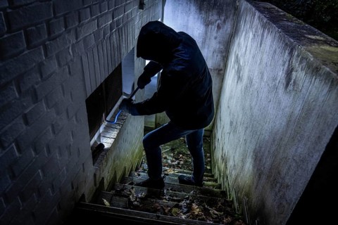 Symbolic image of a house burglary, perpetrator has approached a house from the garden side and