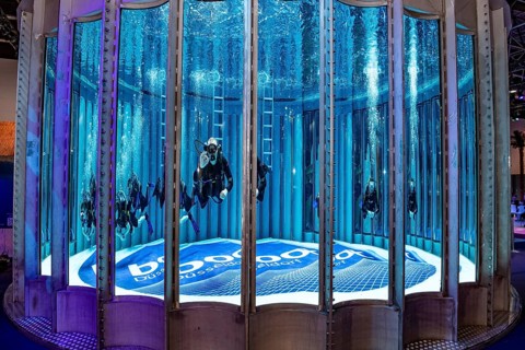 Diver swims dives in diving tower in exhibition hall 12 of Messe boot, on the ground lettering boot
