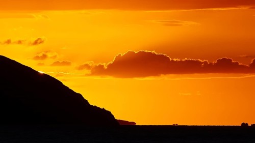 Melancholic coastal atmosphere at sunset with clear clouds over the sea, sunset, Kassos, Karpathos,