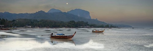 Before sunrise, longtail boats lie at low tide in the harbour at Sivalai Beach, Koh Mook Island,