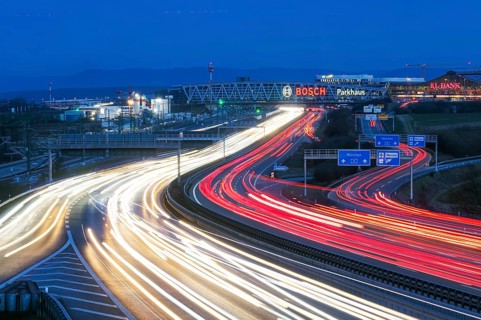 A8 motorway at Stuttgart Airport in the evening. Heavy traffic, lanes of light. Modern architecture