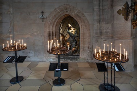 Sacrificial candles, a figure of Jesus at the back in the late Gothic hall church of St George,