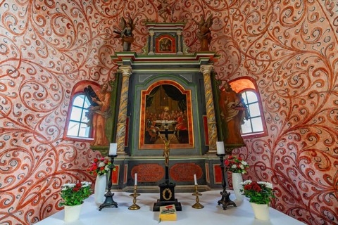 Interior and altar, walls with colourful frescoes in the Romanesque fieldstone church in the