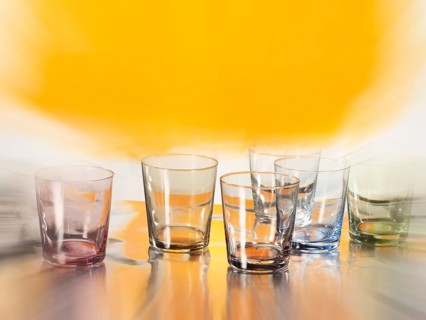 Various glasses on silver foil, yellow coloured area behind, zoom effect, studio shot