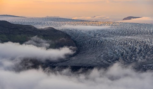 Fog, clouds moving around, glacier ice of the Kötlujökull glacier tongue at sunset, Myrdalsjökull