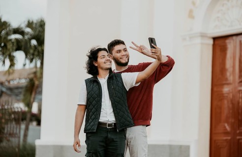 Cheeful friends taking funny selfie on the street. Portrait of funny friends taking a selfie on the