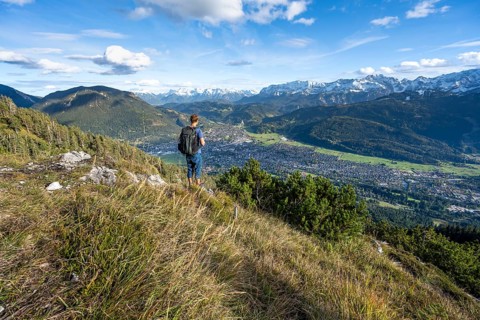 View of Garmisch-Partenkirchen and mountain panorama, mountaineer on hiking trail to Kramerspitz,