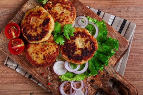 Fried chicken cutlets, minced chicken, with vegetables, on a cutting board, with vegetable salad,