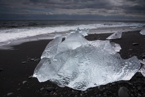 Little icebergs and crushed ice on the black beach at Joekulsarlon glacial lake