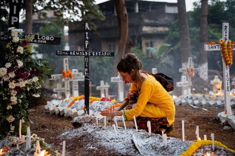 People from Christian community light candles and offer prayers on the grave of their relative