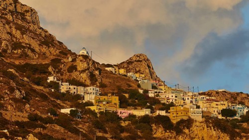 Houses of a village placed in steps on a rocky hill under a morning sky, mountain village Menetes,
