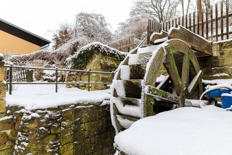 Small overshot waterwheel in the snow, Zschonermühle, Ockerwitz, Dresden, Saxony, Germany, Europe