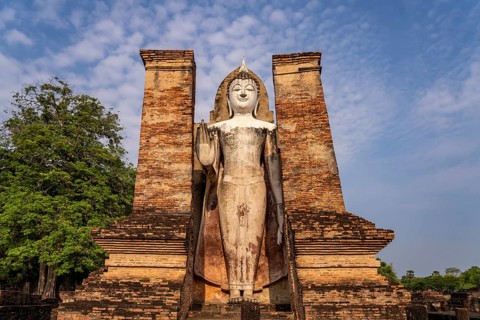 Giant standing Buddha in the Wat Mahathat temple in the UNESCO World Heritage Sukhothai Historical
