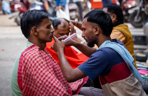 People shave in a street barber shop in Guwahati, India on 1 February 2025