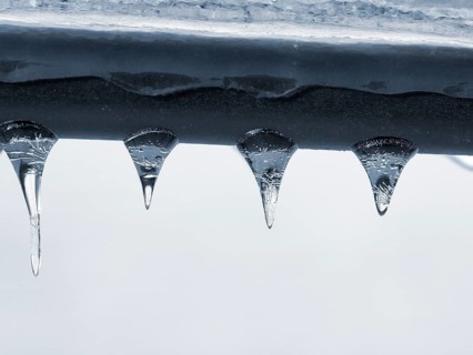 Four icicles hanging from a railing, macro, unusually cold winter 2010, symbolic photo winter