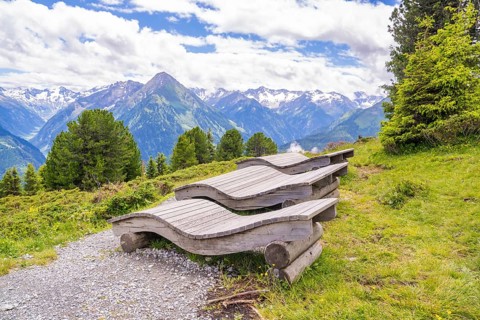 Wooden loungers on a mountain path offer a peaceful way to enjoy the surrounding landscape, Penken,