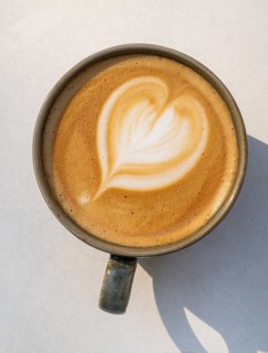 Cappuccino with heart pattern in the crema, coffee cup on a light-coloured background, Copenhagen,