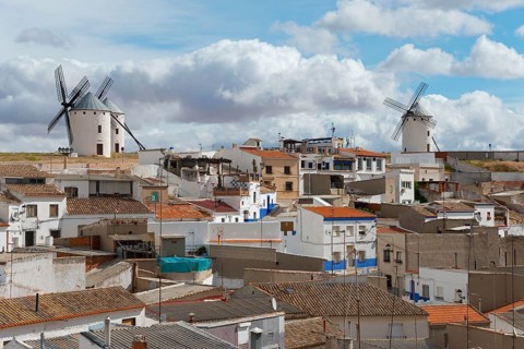 A town view with windmills and houses under a partly cloudy sky, Campo de Criptana, Ciudad Real