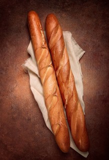 Fresh French baguette, two pieces, top view, on the table, no people