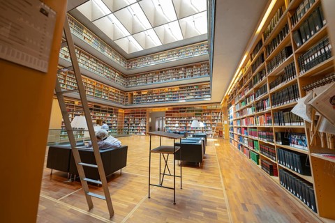 Large modern library with well-stocked bookshelves, ladders and cosy reading area, Weimar, Germany,