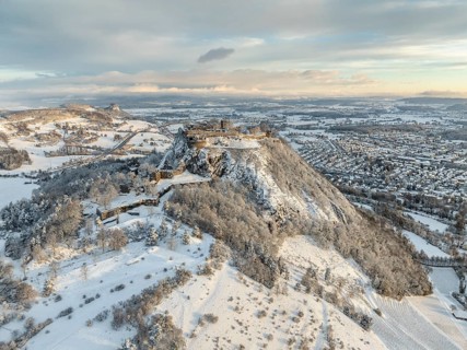 Aerial view of the snow-covered Hegau volcano Hohentwiel with Germany's largest castle ruins on a