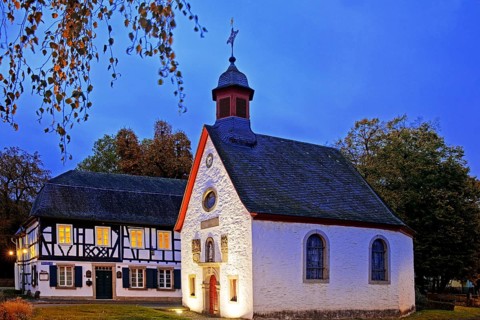 Illuminated St Mary's Chapel in the evening with half-timbered house, Rhöndorf, Bad Honnef, North
