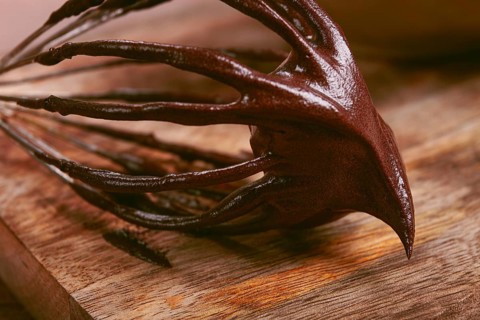 Metal whisk, close-up with chocolate dough, baking, structure and consistency, homemade, top view,