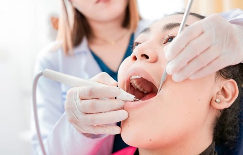 Patient checked by dentist, Dentist doing dental checkup, Close up of dentist checking patient with