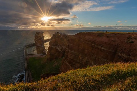 Red red sandstone cliff edge, Heligoland high sea island, Lange Anna, backlight, North Sea, blue