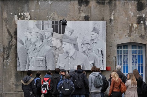 Students with guide in front of the picture of the political prisoners at Fort Breendonk, Belgium,