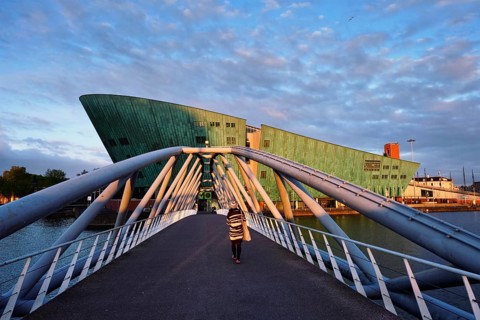 AMSTERDAM, NETHERLANDS, MAY 9, 2017: NEMO Science museum and Mr. J. van der Veldebrug bridge. It is