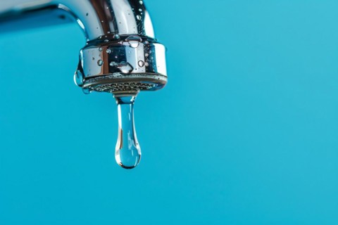 Single drop of water coming out of water tap on blue background. KI generiert, generiert, AI