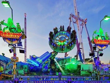 People on the illuminated carousel Mr Gravity in the evening, Cranger Kirmes, Herne, Ruhr area,