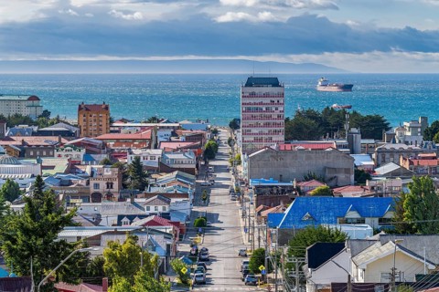 View from a hill over streets and houses to the Strait of Magellan, city of Punta Arenas,