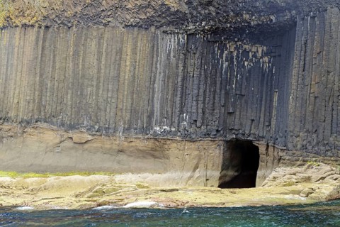 High basalt cliffs with a small cave on the coast, Hebrides Overture, Staffa Island, Inner