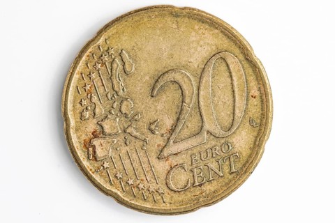 Close-up of the front of a used 20 cent coin, white background