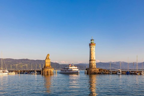 Bavarian Lion, an excursion boat and the lighthouse in the harbour, Lindau Island, Lindau, Lake