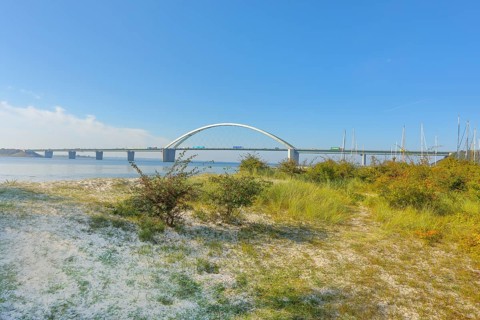 Beach in front of Fehmarnsund Bridge, connects the island of Fehmarn in the Baltic Sea with the