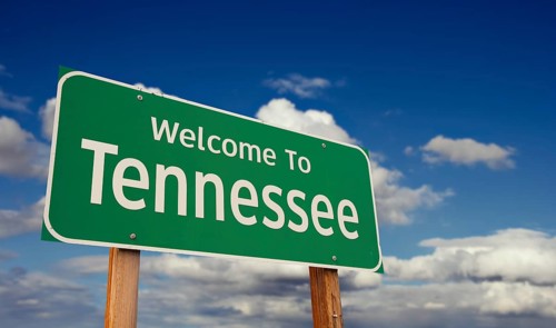 Welcome to tennessee green road sign over blue sky with some clouds