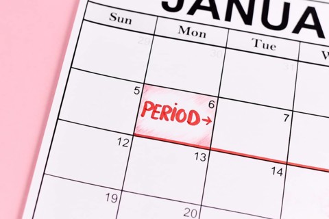 Female period concept with calendar date with period start marked with red word