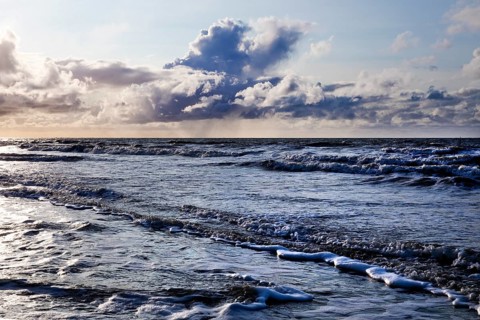 Outgoing tidal fringe in the mudflat landscape with dramatic clouds, North Sea, Norderney Island,