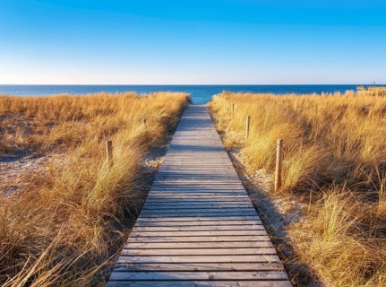 Beach access at the Baltic Sea in the evening light, boardwalk through dunes to the beach, beach