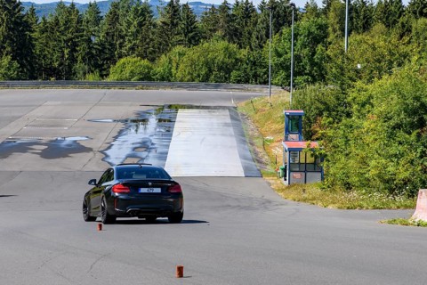 BMW M2 sports car slaloms retains control of vehicle during driving school driving safety training,