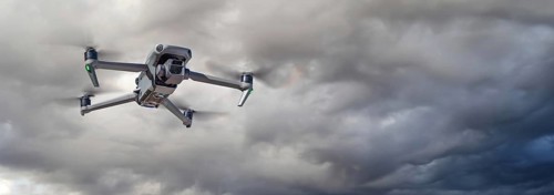 Unmanned aircraft system (UAV) quadcopter drone in the air on A cloudy and stormy day.