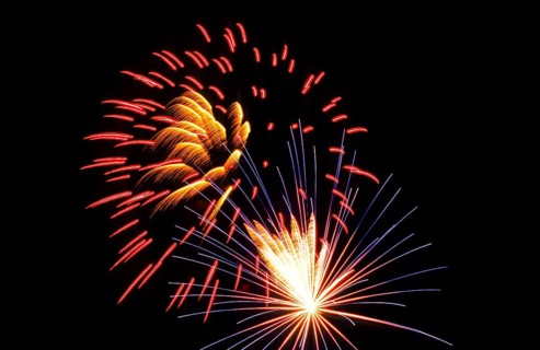 New Year's Eve fireworks, vivid fireworks in the night sky with golden, yellow, red and blue