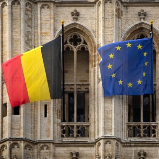Belgian national flag and European flag in front of the baroque façade of the town hall, Hôtel de