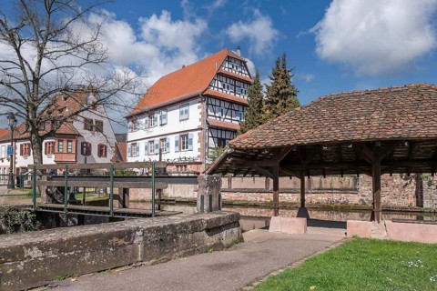 Historic washing place, behind it the historic half-timbered house Restaurant Caveau du Chatelet