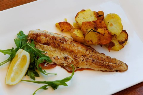 Mediterranean cuisine, fried pike-perch fillet, roast potatoes, fried potatoes, rocket salad, lemon