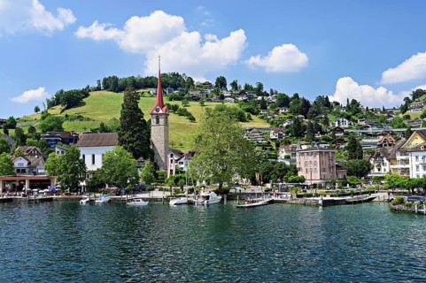 Holiday destination on Lake Lucerne with the parish church of St. Mary and the snow-covered Alps in